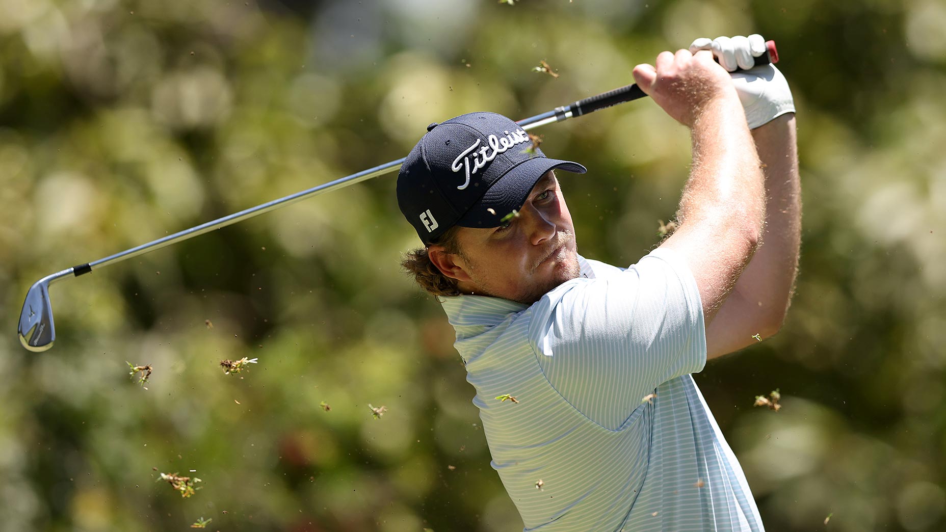 eddie pepperell swings iron in navy hat and beige shirt